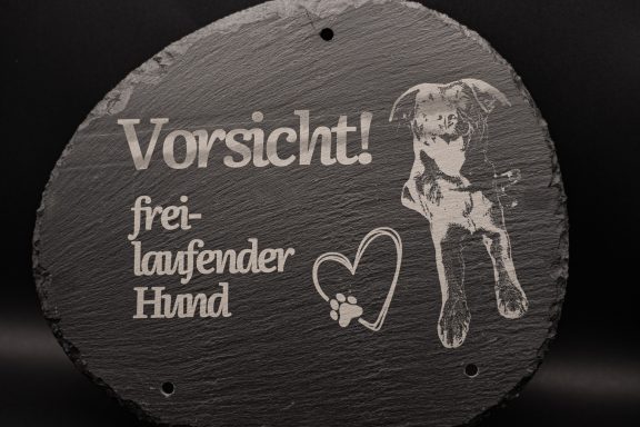 Schild mit der Aufschrift "Vorsicht! freikaufender Hund" und Hundepfote.